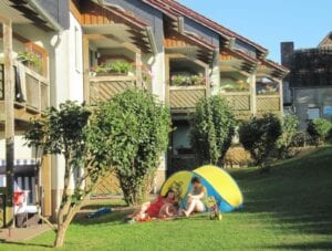 Familie entspannt neben Haus und Garten im Sommer