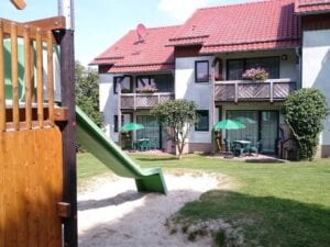 Spielplatz vor Wohnhaus mit Balkon