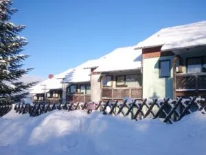 Verschneite Häuser unter blauem Himmel.